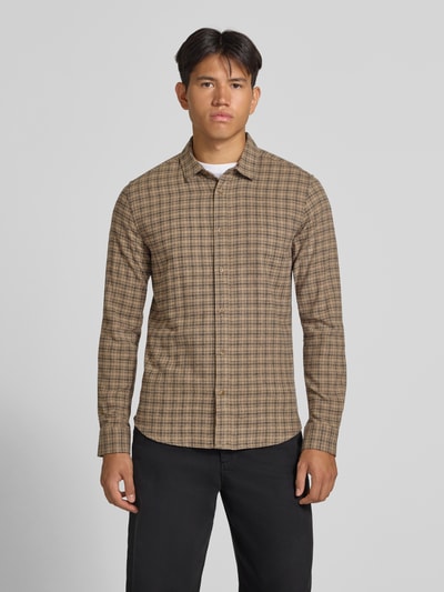 Männermodel trägt Slim Fit Freizeithemd aus reiner Baumwolle Modell 'GUDMUND' von ONLY & SONS, braun kariert, Ganzkörperansicht von vorne.