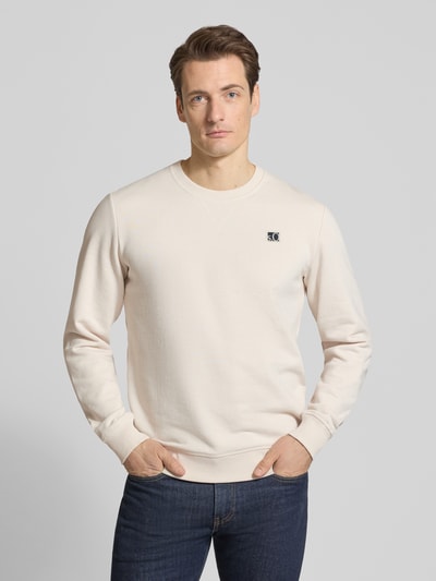 Männermodel trägt Regular Fit Sweatshirt aus Baumwoll-Mix von s.Oliver RED LABEL, efekt: jednolity kolor, krój regular fit, wyhaftowane logo, dekolt okrągły, długi rękaw, prążkowane wykończenie, mieszanka bawełny, dzianina dresowa, jasny kolor, gładka faktura, Ganzkörperansicht von vorne.