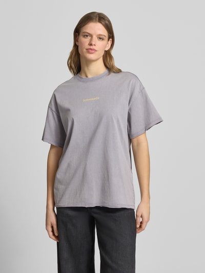 Vrouwenmodel draagt oversized T-shirt uit biologisch katoen model 'KINNA LIFE' van Only in mêlee-look met tekstapplicatie, ronde hals, korte mouw met open rand, rolzoom, materiaal: puur biologisch katoen, voorkant volledig zichtbaar, Ganzkörperansicht von vorne.