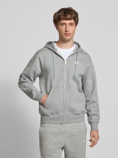 Männermodel trägt Sweatjacke mit Label-Stitching und Känguru-Tasche von Nike in Hellgrau, Baumwoll-Mix, Regular Fit, Ganzkörperansicht von vorne.