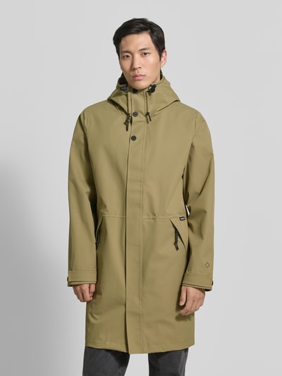 Männermodel trägt olivgrüne Regenjacke mit Kapuze, Kordelzug, Reißverschlusstaschen, Modell 'RAIN EATER' von GOFRANCK, Gerader-Schnitt, Label-Detail, verstellbare Ärmelriegel, Ganzkörperansicht von vorne.