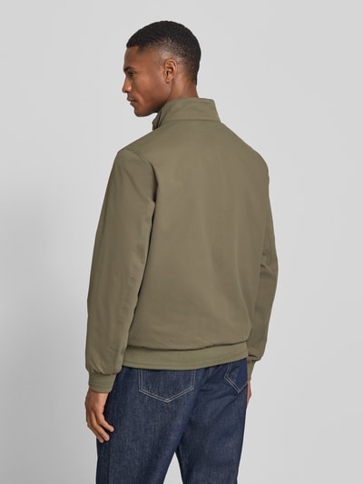 Männermodel trägt Regular Fit Blouson mit Stehkragen von Tom Tailor in Olive, Unifarbe, Twillstruktur, Ganzkörperansicht Rückansicht.