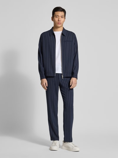 Männermodel trägt Modern Fit Hemdjacke mit Zweiwege-Reißverschluss von Lindbergh im Streifenmuster, Blautöne, Ganzkörperansicht von vorne.