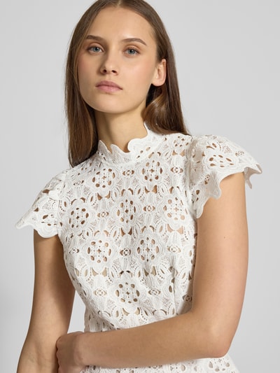 Vrouwenmodel draagt witte Cocktailjurk uit gehaakt kant Model 'ROWEN' van Bardot met ruches, opstaande kraag, nahaufnahme bovenlichaam.