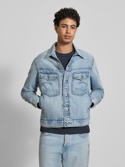 Männermodel trägt Jeansjacke mit Knopfleiste und Brusttaschen Modell 'Dakota' von G-Star Raw aus reiner Baumwolle, Regular-Fit, Ganzkörperansicht von vorne.