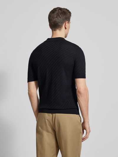 Männermodel trägt Slim Fit Poloshirt mit Lyocell-Anteil von Emporio Armani in Dunkelblau, Strick-Optik, elastische Abschlüsse, Ganzkörperansicht Rückansicht.