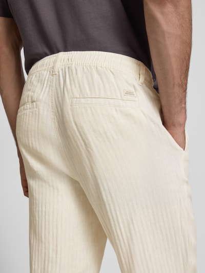 Mannenmodel draagt Hose aus Leinen-Baumwoll-Mix Modell 'MAXIM' van Blend in licht beige, mix van linnen en katoen, relaxed fit, elastische band, bandwijdte maat M 42 cm, binnenbeenlengte maat M 78 cm, detailopname rugaanzicht.