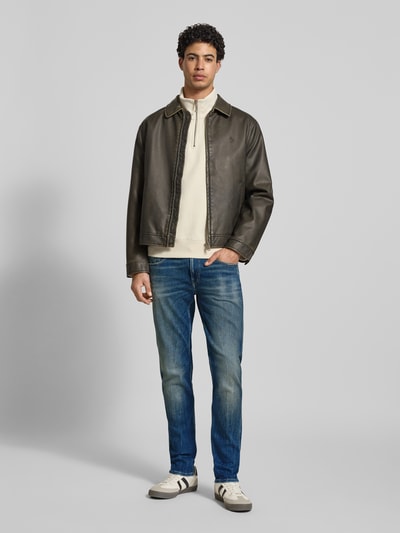 Männermodel trägt Slim Fit Jeans aus Baumwoll-Mix im Destroyed-Look von Replay in Blau, Kontrastnähte, 5-Pocket-Design, Ganzkörperansicht von vorne.