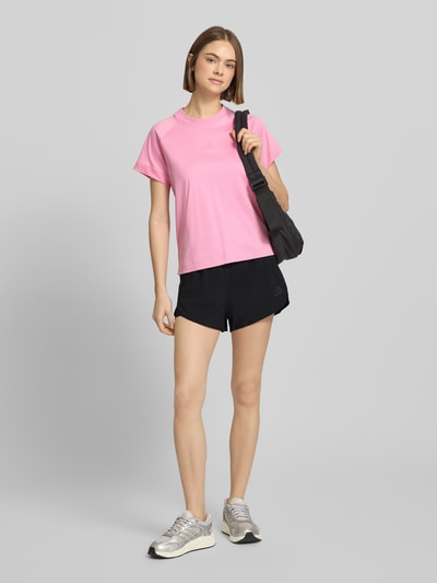 Frauenmodel trägt Regular Fit Shorts mit Reißverschlusstaschen von adidas Sportswear, schwarz, elastischer Bund, Ganzkörperansicht von vorne.