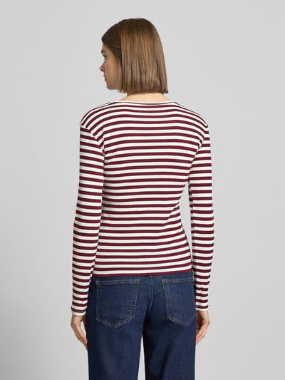 Frauenmodel trägt Slim Fit Langarmshirt aus Baumwoll-Mix von Pieces, gestreift, two tone, Rippstrick, dunkelrot-weiß, Ganzkörperansicht Rückansicht.