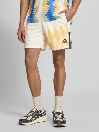 Männermodel trägt Regular Fit Sweatshorts mit Strukturmuster von adidas Sportswear, Optik: Unifarben/Strukturiert, feines Strukturmuster, Label-Print, Kontraststreifen-Print, elastischer Bundabschluss mit Tunnelzug, seitliche Eingrifftaschen, helle Farben, weiche Textur, Ganzkörperansicht von vorne.