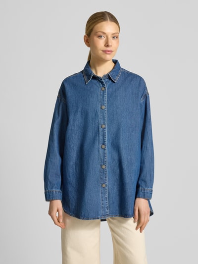 Frauenmodel trägt Oversized Jeansbluse mit überschnittenen Schultern Modell 'Hilma' von My Essential Wardrobe, reine Baumwolle, Umlegekragen, mittleres Jeansblau, lockerer Schnitt, Ganzkörperansicht von vorne.