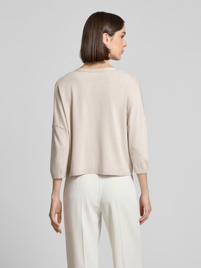 Frauenmodel trägt schimmernde Strickjacke mit 3/4-Arm von comma, Relaxed Fit, V-Ausschnitt, Knopfleiste, beige, Ganzkörperansicht Rückansicht.