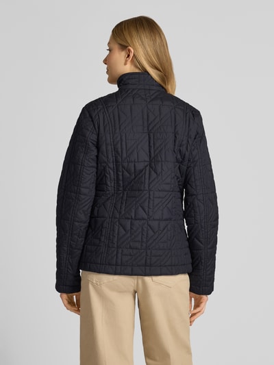 Frauenmodel trägt Steppjacke mit Stehkragen und Eingrifftaschen von Fuchs Schmitt in Dunkelblau, strukturierte Oberfläche, Ganzkörperansicht Rückansicht, Regular Fit, Knopfleiste, Rückenlänge 64 cm, Schulterbreite 43 cm, Brustweite 49 cm, Ärmellänge 65 cm.