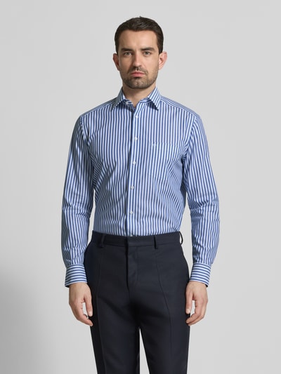 Männermodel trägt Regular Fit Business-Hemd mit Kentkragen von OLYMP, blau-weiß gestreift, reine Baumwolle, Ganzkörperansicht von vorne.