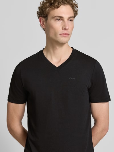 Mannenmodel draagt Regular Fit T-shirt uit zuivere katoen van s.Oliver RED LABEL in effen zwart, v-hals, gladde textuur. Nahaufnahme bovenlichaam.