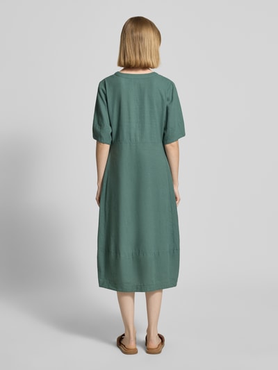Frauenmodel trägt knielanges Kleid aus Leinen-Viskose-Mix Modell 'Lava' von FREE/QUENT in A-Linie, Unifarbe, Ganzkörperansicht Rückansicht, V-Ausschnitt, Knopfleiste, Rückenlänge 96 cm, Brustweite 43 cm, Ärmellänge 29 cm.