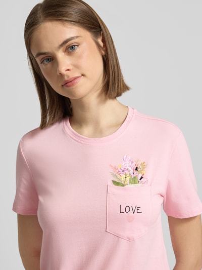 Frauenmodel trägt Regular Fit T-Shirt aus reiner Bio-Baumwolle Modell 'POLLY' von Only in Optik: Unifarben mit Statement-Print-Applikation und Motiv-Stitching, Rundhals, Kurzarm, Jersey, Brusttasche; Nahaufnahme Oberkörper.