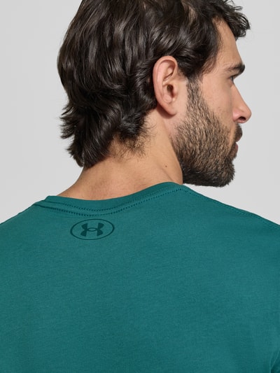 Männermodel trägt Regular Fit T-Shirt mit Logo-Print Modell 'Left' von Under Armour aus Baumwoll-Mix, Nahaufnahme Rückansicht.