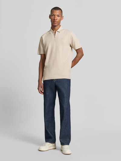 Männermodel trägt Regular Fit Poloshirt aus reiner Baumwolle Modell 'Pe_RibNylon' von BOSS Orange in Beige, glatte Textur, Ganzkörperansicht von vorne.