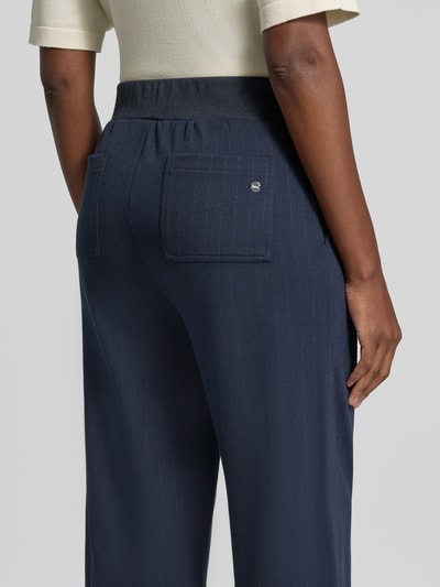 Vrouwenmodel draagt donkerblauwe wijdte broek met viscose van Brax, fijne krijtstrepen, zichtbare zakken, dames, close-up rugaanzicht.