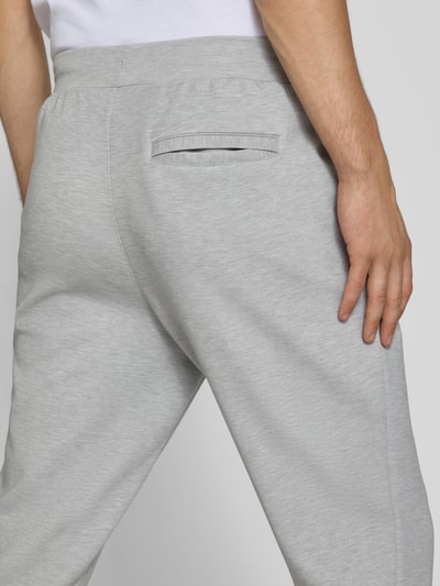 Männermodel trägt Regular Fit Sweatpants mit Lyocell-Anteil von PUMA PERFORMANCE in Hellgrau, elastischer Bund, Ganzkörperansicht Rückansicht.