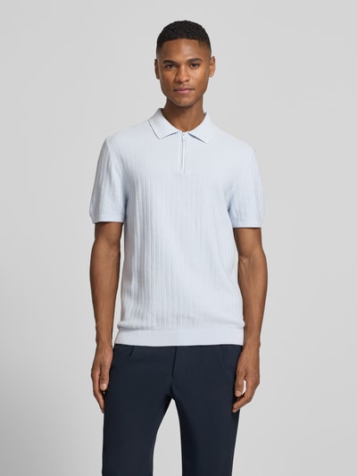 Männermodel trägt Poloshirt mit kurzem Reißverschluss und Polokragen von MCNEAL aus Reiner Bio-Baumwolle, Body Fit, Gerippte Abschlüsse, Ganzkörperansicht von vorne.