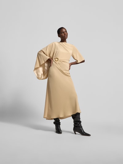 Frauenmodel trägt Slim Fit Maxikleid mit Zierbesatz Modell von Joseph aus Acetat-Mix in Beige, mit Raffungen, Asymmetrischer-Look, Ganzkörperansicht von vorne. Gesamtlänge 152 cm, Brustweite 40 cm, Ärmellänge 37 cm.
