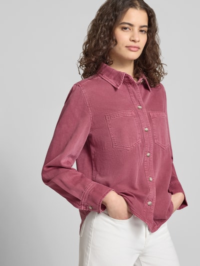 Kobiece modelka nosi Regular Fit Jeansbluse aus reiner Baumwolle Modell 'SILLA' von Only, różowy denim, długie rękawy, naszywane kieszenie, guziki, widok z przodu na górną część ciała.