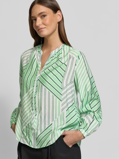 Frauenmodel trägt Relaxed Fit Langarmbluse aus Viskose-Mix von s.Oliver RED LABEL mit grün-weißem Allover-Muster, Nahaufnahme Oberkörper.