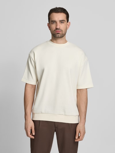 Männermodel trägt Oversized T-Shirt mit Rundhalsausschnitt von Lindbergh, Baumwoll-Mix, Label-Detail, cremefarben, Ganzkörperansicht von vorne. Rückenlänge bei Größe M: 70 cm.