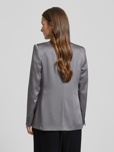 Frauenmodel trägt Regular Fit Blazer mit Pattentaschen von Luisa Cerano in glänzendem Grau, Reverskragen, Knopfverschluss, Rückenlänge 67 cm, Brustweite 40 cm, Ärmellänge 61 cm, Ganzkörperansicht Rückansicht.