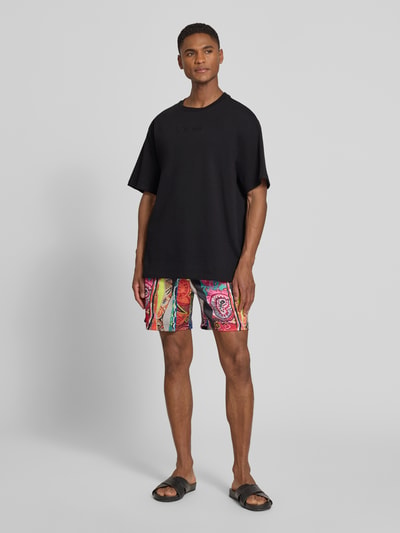 Männermodel trägt Relaxed Fit T-Shirt mit Logo-Stitching Modell 'Ikarus' von COLUCCI, schwarz, reine Baumwolle, Ganzkörperansicht von vorne.