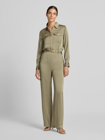 Frauenmodel trägt Jumpsuit mit Taillengürtel von MICHAEL Michael Kors in Oliv, Satin mit Crinkle-Optik, Ganzkörperansicht von vorne.