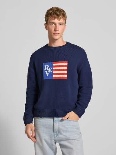 Männermodel trägt Regular Fit Strickpullover aus Baumwoll-Mix von REVIEW in Dunkelblau mit Motiv-Stitching, Nahaufnahme Oberkörper.