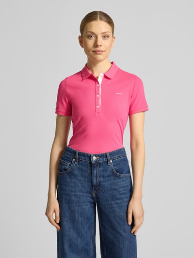 Frauenmodel trägt Slim Fit Poloshirt mit Label-Stitching von Gant aus Baumwoll-Elasthan-Mix, Knopfleiste, Rückenlänge 59 cm, Ganzkörperansicht von vorne.