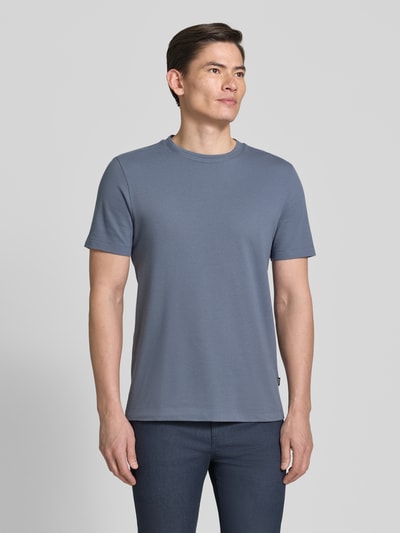 Männermodel trägt Regular Fit T-Shirt aus Baumwoll-Mix Modell 'TIBURT 240' von BOSS in unifarbenem Blau, Mouliné-Garn, Ganzkörperansicht von vorne.