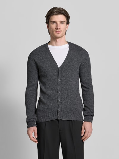 Männermodel trägt Strickjacke mit Knopfleiste Modell 'KARL' von Casual Friday, Baumwoll-Mix, Slim Fit, dunkelgrau, Ganzkörperansicht von vorne.
