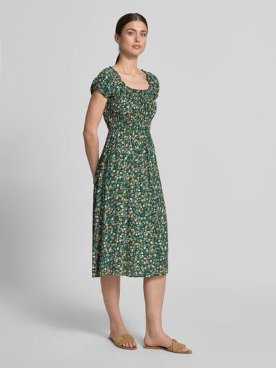 Modelka kobieca nosi Midikleid aus Viskose mit Smok-Details od Apricot, zielony, wzór w kwiaty, krój taliowany, szerokość w rozmiarze S 40 cm, długość 105 cm, okrągły dekolt z falbankami, rękawy z falbanami, widok całej sylwetki z przodu