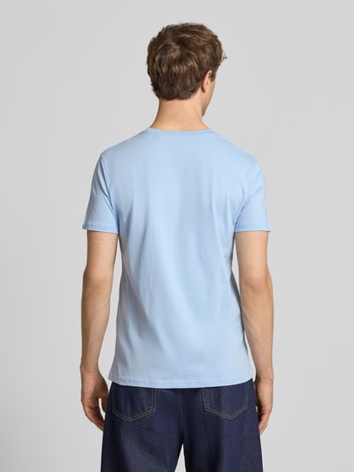 Männermodel trägt T-shirt mit Labelprint und ronde hals van Alpha Industries, puur katoen, regular fit, ruglengte maat M 67 cm, Ganzkörperansicht Rückansicht.