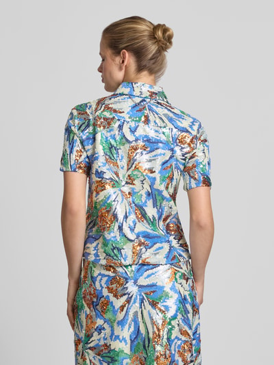 Frauenmodel trägt Hemdbluse mit Allover-Pailettenbesatz von Rabanne in Blau, Weiß, Braun, taillierte Passform, Kurzarm, Ganzkörperansicht Rückansicht.