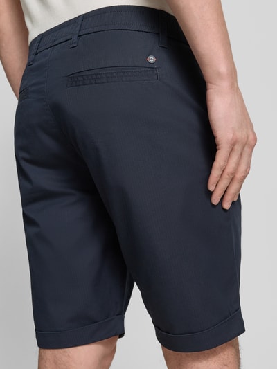 Männermodel trägt Chino-Shorts mit Gesäßleistentaschen von Lerros in Dunkelblau, Baumwoll-Mix mit Stretch-Anteil, Ganzkörperansicht Rückansicht.