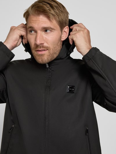 Männermodel trägt Regular Fit Jacke mit Stehkragen von Emporio Armani in Schwarz, Zweiwege-Reißverschluss, Nahaufnahme Oberkörper.