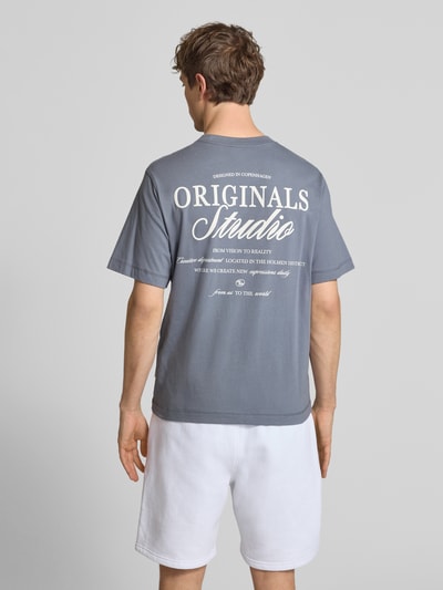 Männermodel trägt T-shirt met statementprint Modell 'NORREBRO' van Jack & Jones, puur katoen, recht model, ruglengte maat M 68 cm, Ganzkörperansicht Rückansicht.