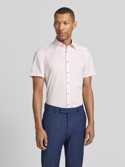 Męski model nosi Slim Fit Business-Hemd mit Kentkragen od OLYMP Level Five, jasnoróżowy, czysta bawełna, krój slim fit, kent, krótki rękaw z mankietem, guziki, długość pleców w rozmiarze 40: 70 cm, szerokość ramion w rozmiarze 40: 40 cm, długość rękawa w rozmiarze 40: 24 cm, przód, zdjęcie całej sylwetki.