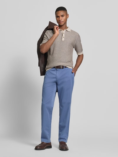 Męski model nosi jasnoniebieskie spodnie Straight Fit Stoffhose mit Lyocell-Anteil Modell 'Everest' od Brax z bawełnianej mieszanki z lyocellem, boczne i tylne kieszenie, kieszonka na monety, zapięcie na guzik i zamek, szerokość w rozmiarze 50: 46 cm, długość nogawki 82 cm, tekstura gładka, widok całej sylwetki od przodu.