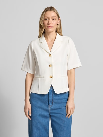 Frauenmodel trägt weißen Damen Blazer mit Viskose-Anteil Modell 'Kate' von ICHI, Reverskragen, Halbarm, Paspeltaschen, taillierte Passform, durchgängige Knopfleiste, Elastischer-Material-Mix, Ganzkörperansicht von vorne.