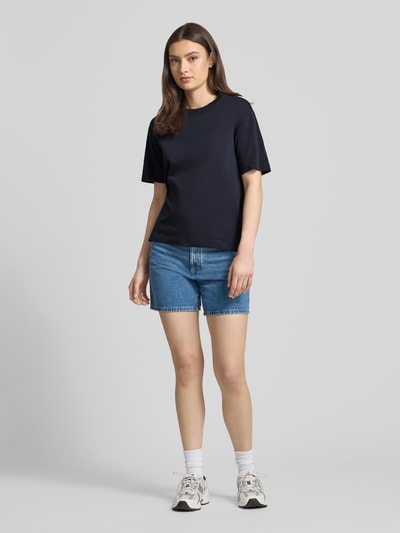 Frauenmodel trägt Regular Fit T-Shirt aus reiner Baumwolle von Marc O'Polo Denim, unifarben in Dunkelblau, Ganzkörperansicht von vorne.