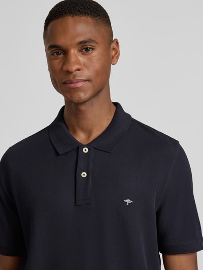 Männermodel trägt Regular Fit Poloshirt mit Label-Stitching von Fynch-Hatton, reine Baumwolle, Polokragen, Nahaufnahme Oberkörper.