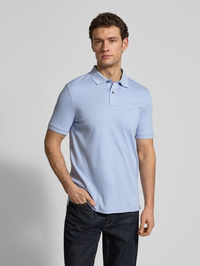 Männermodel trägt Regular Fit Poloshirt mit Logo-Stitching von Fynch-Hatton in Hellblau aus Baumwolle, Ganzkörperansicht von vorne.